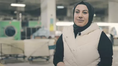 A woman in Turkiye at a factory, speaking to camera