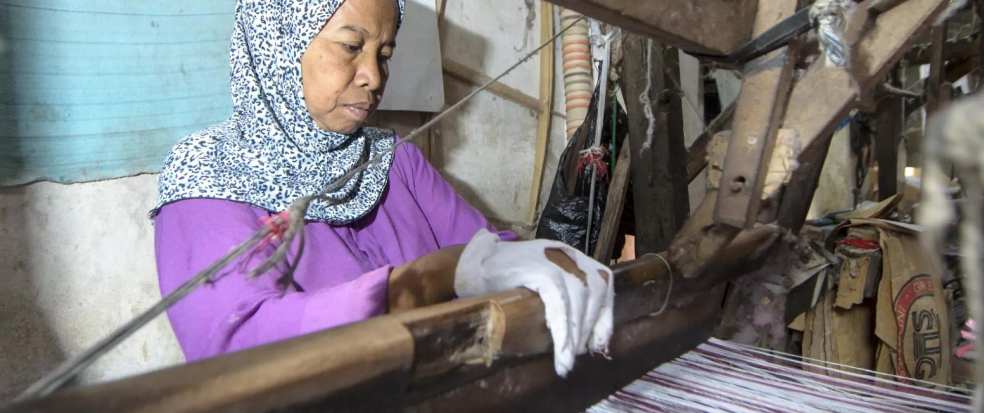 Woman weaving on a handicraft loom